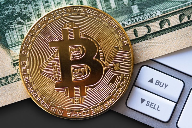bitcoin-coin-on-dollar-bill-with-buttons-2021-08-26-17-04-32-utc.jpg